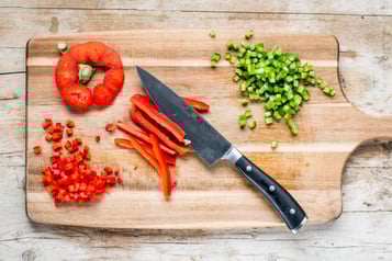 Für den Laugen-Hotdog mit Senfcreme die Paprika würfeln