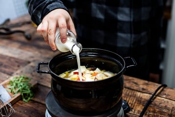 Butter, Schalotten, Äpfel und Sellerie in einen Topf geben, mit Apfelwein, Gemüsebrühe und Sahne aufgießen und köcheln lassen.