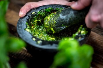 Basilikumpesto wird im Mörser gemacht