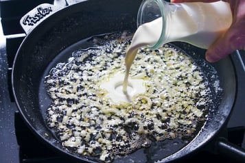 Zwiebeln werden für Tagliatelle mit Trüffeln mit Sahne abgelöscht