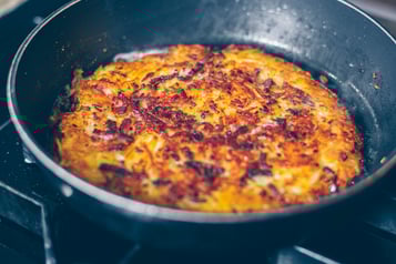 Rösti trentino wird in einer Pfanne angebraten