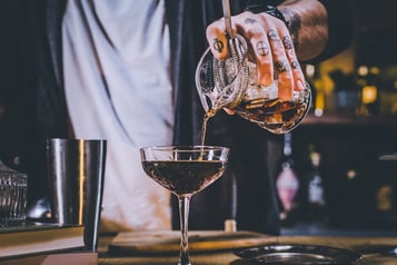 Einfüllen des White Russian mit Hilfe eines Strainers.