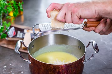 Parmigiano Reggiano in Parmesansauce reiben