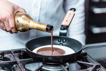 Baileys Chocolat Luxe wird zu der Sahne in einer Pfanne gegeben.