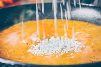 Reis wird in die Sauce für Pomodori ripiene gegeben