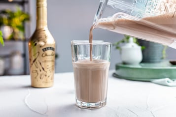 Espressocreme wird aus dem Standmixer in ein Glas gegeben.