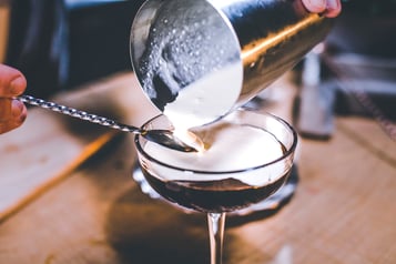 Sahne floaten in den White Russian mit einem Rührlöffel.