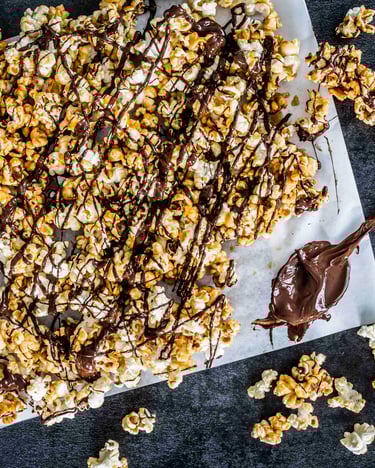 Popcorn mit Karamell und Schokolade auf Backpapier.