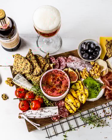 Snackplatte mit Knäckebrot, Rote-Bete-Hummus und jede Menge Brotzeitleckereien. Dazu ein Krombacher Bier.