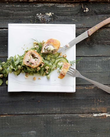 Cordon Bleu mit Wasabinüssen und Schmorgurke auf weißem Teller.