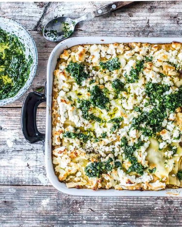 Lasagne mit Lammhackfleisch, Datteln und Harissa in einer Auflaufform auf Holzuntergrund.