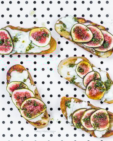 Bruschetta mit Gorgonzola, Feigen und Honig auf weißem Untergrund mit schwarzen Punkten