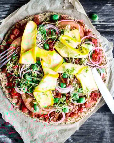 Vegane Blumenkohlpizza auf einem dunklen Holzuntergrund