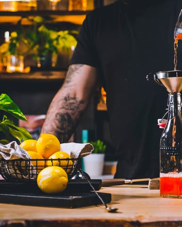 Karotten-Sirup wird durch einen Trichter in eine Flasche gefüllt.