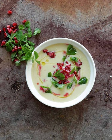 Knoblauchsuppe in der Suppenschüssel mit Granatapfelkernen und Kräutern