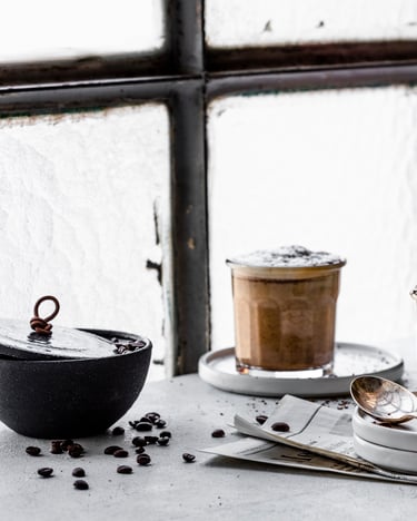 Bitterschokoladen-Cremaccino im Tumbler vor Fenster mit Melitta Bellacream Intenso Packung.