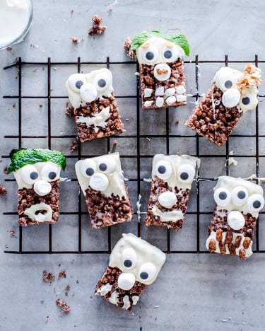 Schoko-Krispie-Riegel mit weißer Schokolade und Wackel-Augen dekoriert.