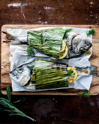 Dorade in Bananenblätter eingewickelt zu Fischpäckchen für den Grill mit Dill, Zitrone und Salbei.