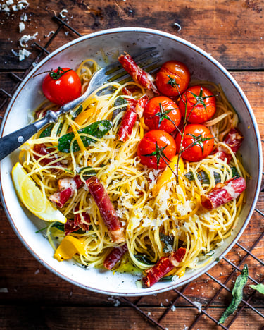Spaghettini in Zitronensauce und Parmaschinken auf Holzuntergrund