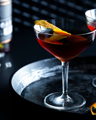 Tipperary Cocktail mit einer Orangenzeste in zwei Cocktailschalen.