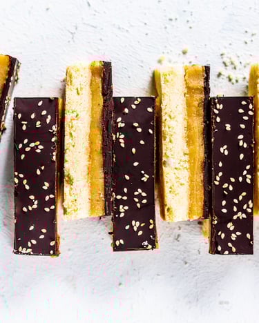 8 Shortbread in eine Reihe gelegt, etwas versetzt auf weißem Untergrund.