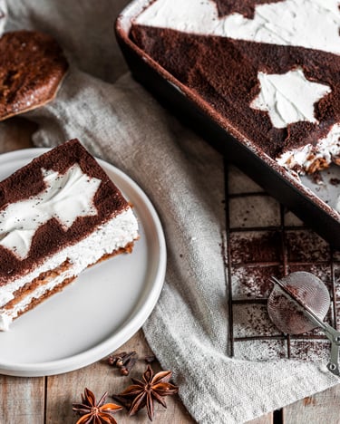 Angeschnittenes Lebkuchen-Tiramisu mit Kakao-Deko und Zimtstangen