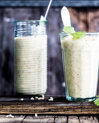 3 Gläser mit einem hellen Shake gefüllt vor einem Holzhintergrund.