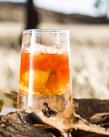 Erfrischender goldorangener Cocktail mit Whiskey, Angostura Bitters, Zitronenlimonade auf Eis.