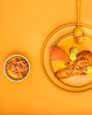 Ein Süßkartoffelkumpir mit Pfirsich Paprika Chutney auf orange-farbenen Teller sowie Hintergrund