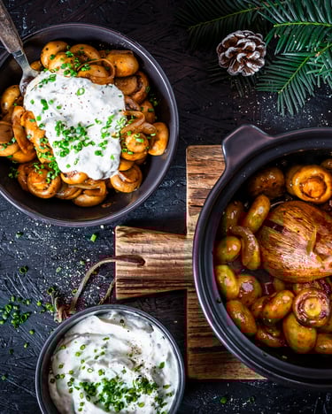 gebratene Champignons mit Knoblauch-Dip in einer Pfanne, daneben eine Schale mit Dip und eine Pfanne mit Champignons