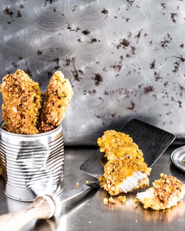 Chickensticks in einer Konservendose serviert neben einem Pfannenwender