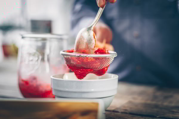 New York Cheesecake Mit Tresor Und Himbeersoße Himbeeren Durch Sieb Streichen