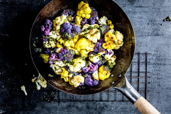 Eine Pfanne mit gelben und violetten Blumenkohlröschen