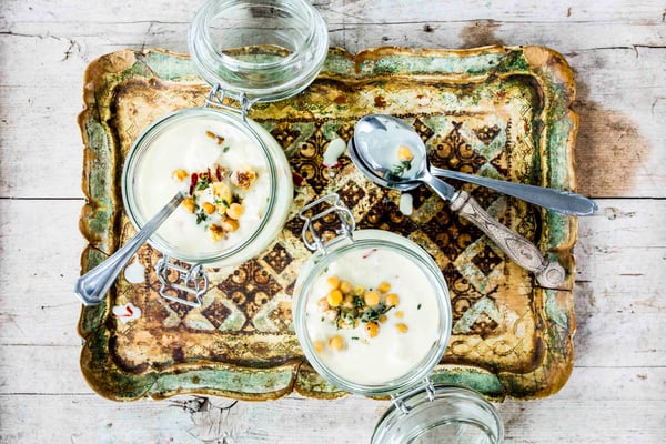 Blumenkohlsuppe in Weckgläsern mit Deckel auf einem Serviertablett mit Besteck von oben