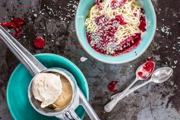 Klassisches Spaghettieis mit Sahne, Erdbeersauce und weißen Schokoraspeln