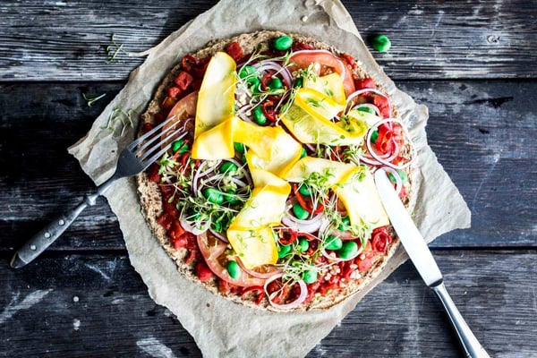 Vegane Blumenkohlpizza auf einem dunklen Holzuntergrund