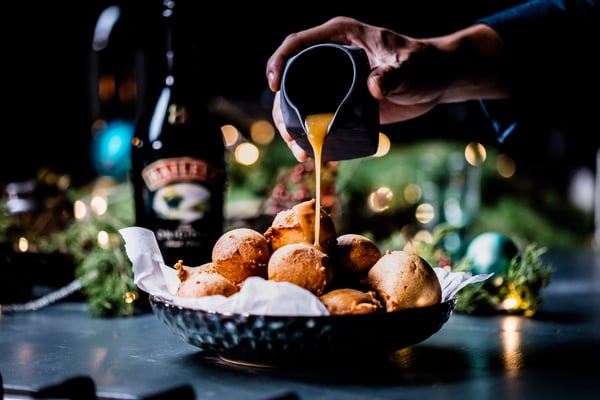 Quarkbällchen mit Baileys-Schokosauce servieren.