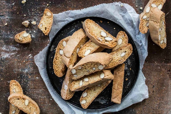 Cantuccini mit Mandeln auf Platte mit blauer Serviette