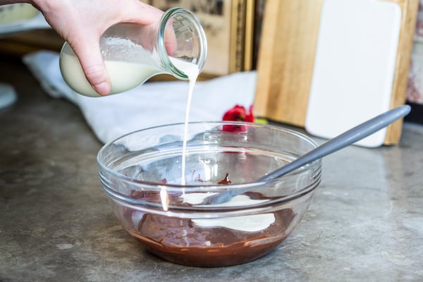 Sahne wird mit flüssiger Schokolade zu einer Ganache vermischt